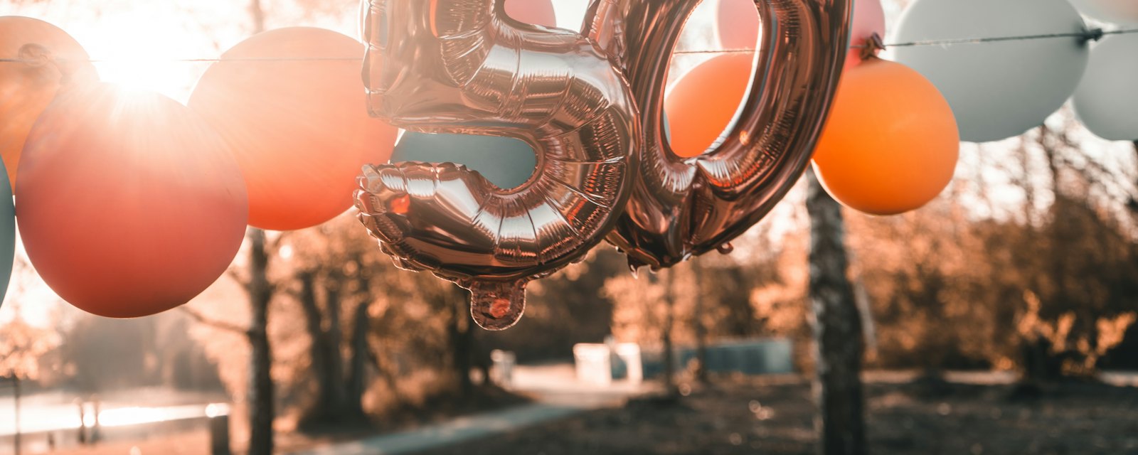 Rose-gold number 50 balloons glowing in the sunlight