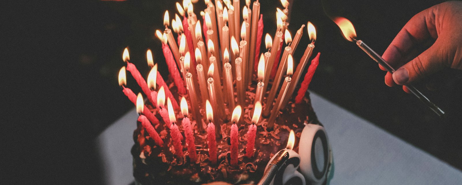 A birthday cake covered in lit red candles