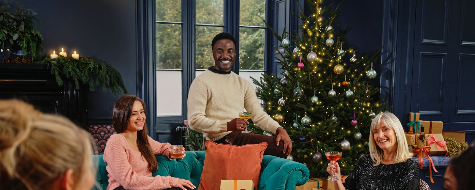 Friends laughing together around a Christmas tree