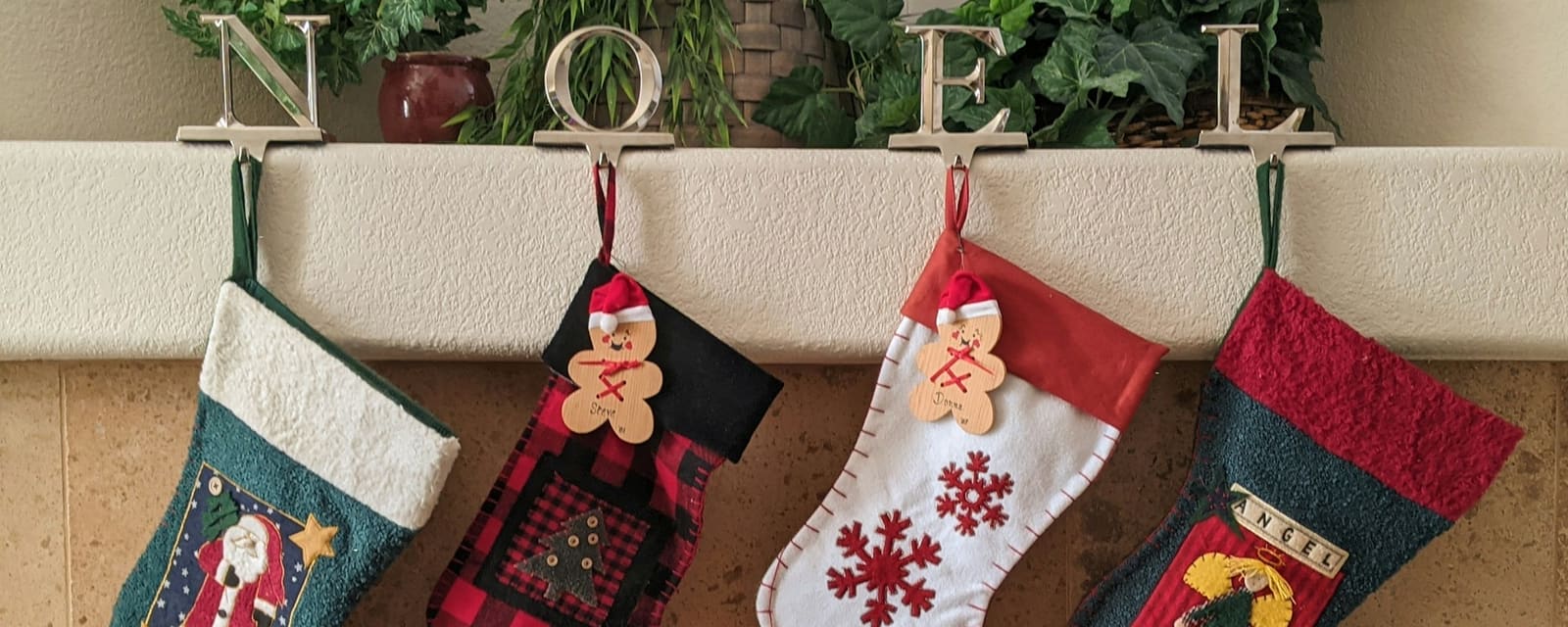 Four Christmas stockings hanging above a fireplace
