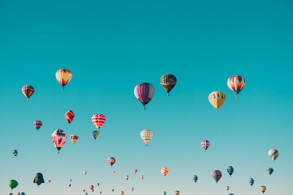 Hot-air balloons drifting across a blue sky
