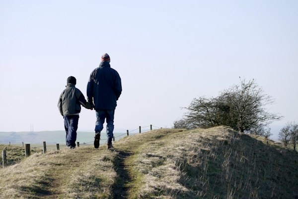 A father and son walking together in the countryside