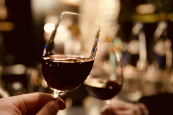 Two glasses of red wine raised in a toast