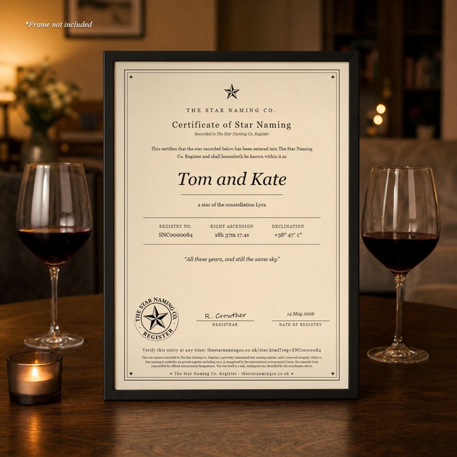A star certificate, “Tom and Kate”, framed on a table between two glasses of red wine