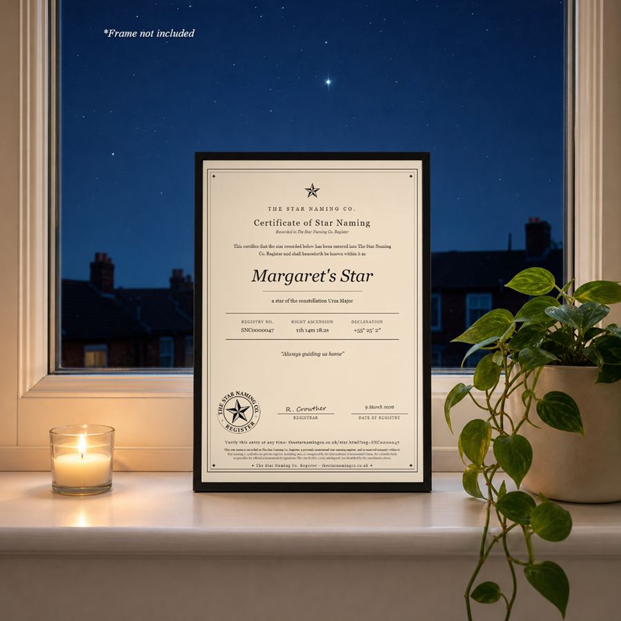 A memorial star certificate, “Margaret’s Star”, framed on a windowsill beside a candle at night